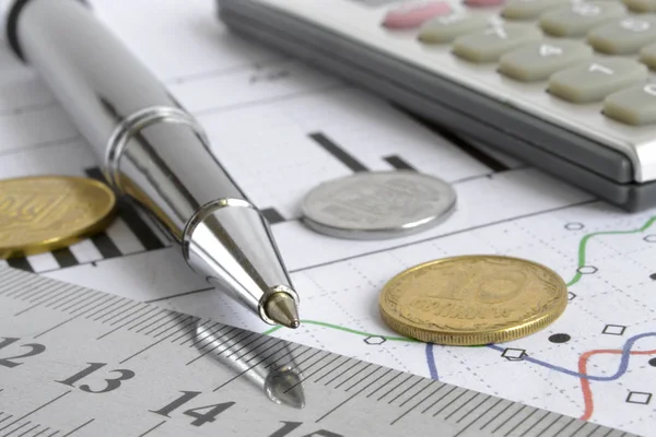 Para, hesap makinesi, grafik ve kalem ile mali geçmiş.