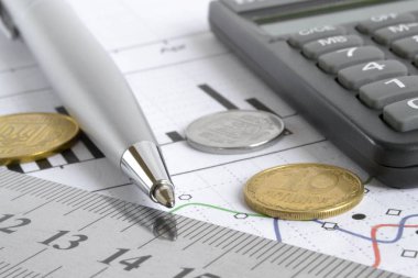 Para, hesap makinesi, grafik ve kalem ile mali geçmiş.