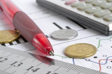 Para, hesap makinesi, grafik ve kalem ile mali geçmiş.