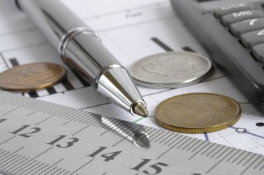 Para, hesap makinesi, grafik ve kalem ile mali geçmiş.