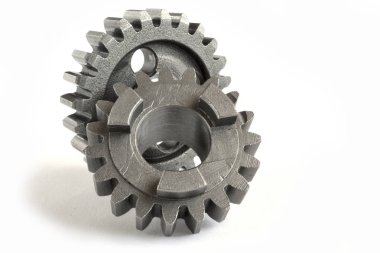 Beyaz arka planda iki yakın çekim metal dişli..