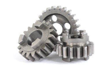 Beyaz arka planda üç yakın çekim metal dişli..