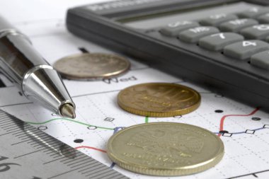 Para, hesap makinesi, grafik ve kalem ile mali geçmiş.