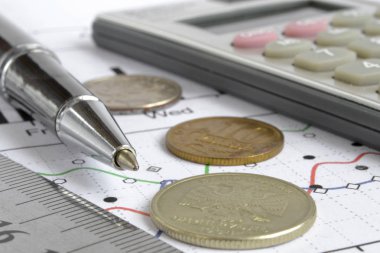 Para, hesap makinesi, grafik ve kalem ile mali geçmiş.