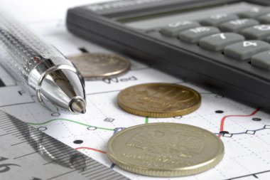 Para, hesap makinesi, grafik ve kalem ile mali geçmiş.