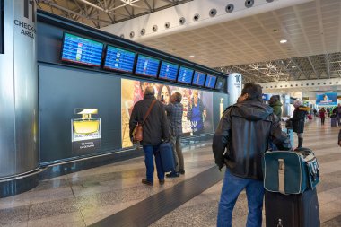 Milano Malpensa, İtalya - Kasım, 2017 yaklaşık: uçuş bilgileri önünde duran yolcular Milan-Malpensa airport adlı monitörler görüntülemek.