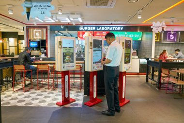 Busan, Güney Kore - Mayıs, 2017 yaklaşık: adam kendini Burger laboratuvar Gimhae Havalimanı, dış hatlar terminali noktasında sipariş kullanın.