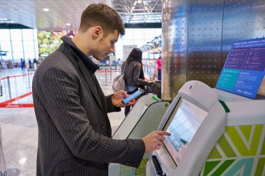 Milan Malpensa, İtalya - Kasım, 2017 yaklaşık: bir yolcu kullanın Alitalia self servis check-in kioskları Milan-Malpensa Havaalanı, Terminal 1. 