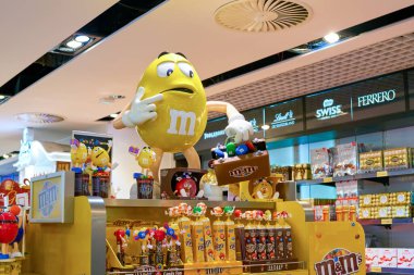 Varşova, Polonya - Kasım 2017: M & M sarı karakter Varşova Chopin Havaalanı 'ndaki Aelia Duty Free mağazasında sergileniyor.