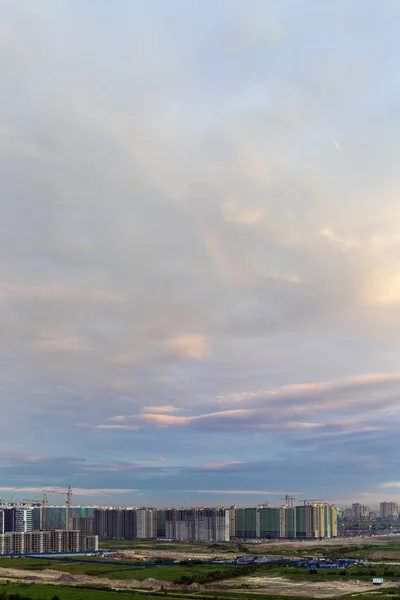 morning sky with clouds and a rainbow over the city