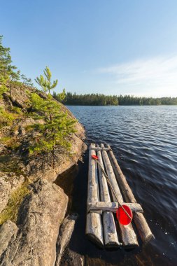 Gölün kayalık kıyısından bir sal ile manzara