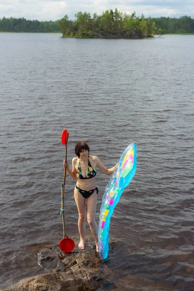 エアコンのマットレスと湖のパドルを持つ女性 — ストック写真