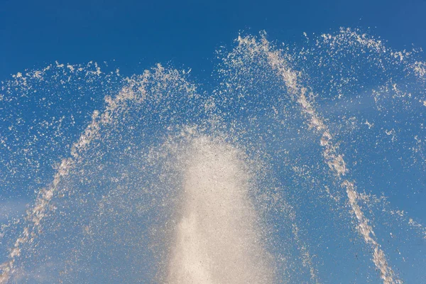 青い空を背景に抽象的なしぶきの噴水 — ストック写真