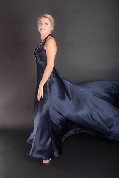 黒の背景に濃い青のイブニング ドレスの女の子 — ストック写真