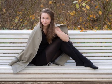 kız beyaz bir Bank üzerinde yağmurluk