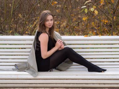 kız beyaz bir Bank üzerinde yağmurluk