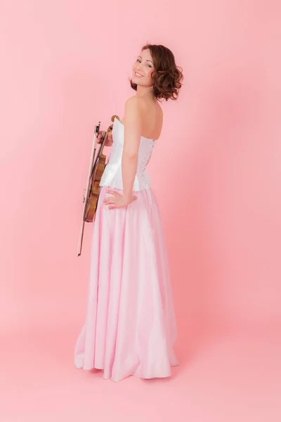 苗条的女人与小提琴在粉红色的背景 — 图库照片