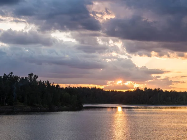 Yaz aylarında bulutlu bir orman göl üzerinden günbatımı