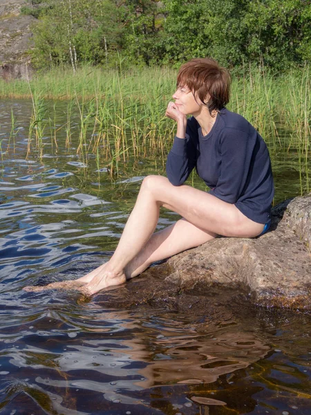 Göl Yakınındaki Bir Kayaya Oturan Kadın — Stok fotoğraf
