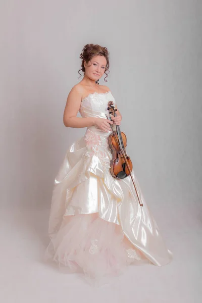 一个穿着白色裙子的女孩的工作室肖像与小提琴 — 图库照片