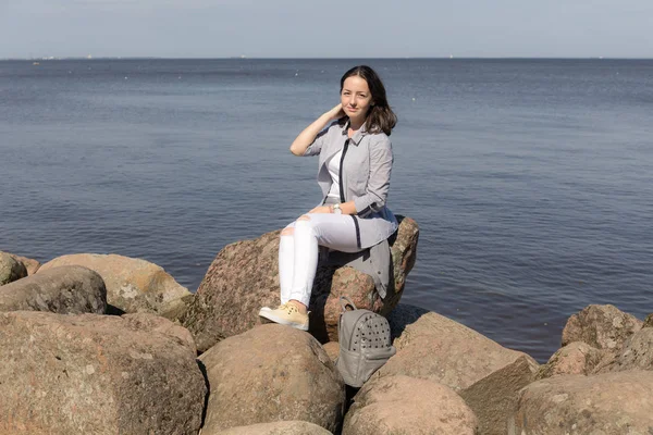 Adolescente chica en las rocas por el mar —  Fotos de Stock