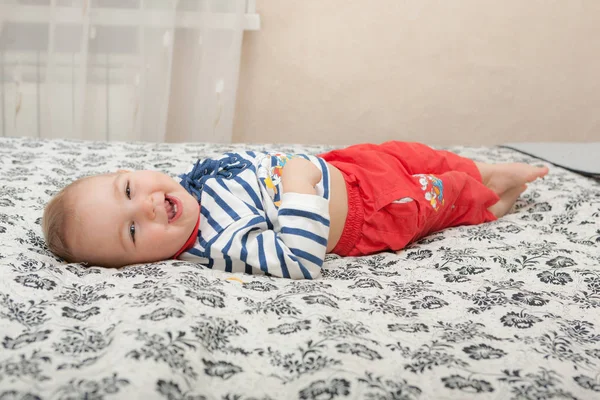 Cheerful baby lying on the bed — Stock Photo, Image