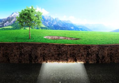 Din kavramı. Işık ışınları yerdeki bir delikten bir doğa arka planda karanlık mağaranın içine akışı.