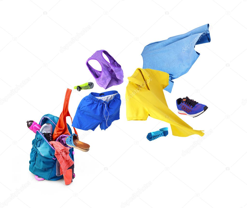 Clothing. Sports backpack, from which flies clothes and shoes, isolated on white background