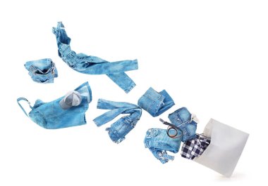 Giyim kağıt çantasından beyaz bir arka plan üzerinde uçuyor