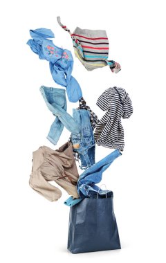 Giyim kağıt çantasından beyaz bir arka plan üzerinde uçuyor