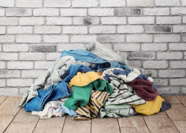 Duvara yakın katta elbise yığını