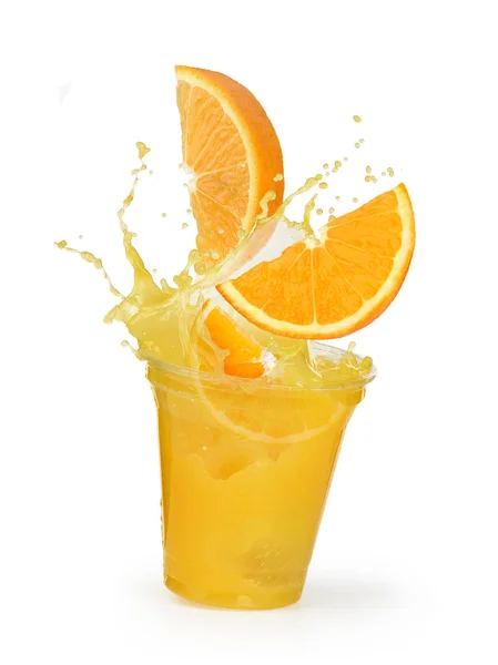 Sinaasappelsap splash met sinaasappels in een plastic beker — Stockfoto