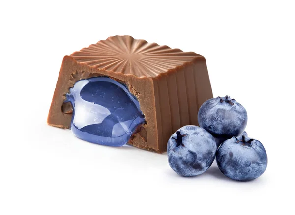 Bonbons au chocolat avec remplissage de bleuets sur fond blanc — Photo