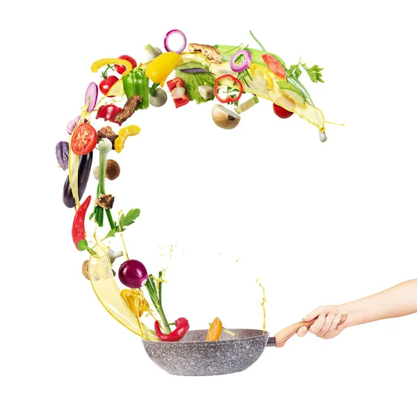 Kochkonzept. Gemüse fliegt vereinzelt aus der Pfanne — Stockfoto