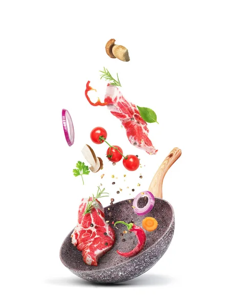 Kochkonzept. Gemüse und Fleisch fallen auf eine Pfanne — Stockfoto