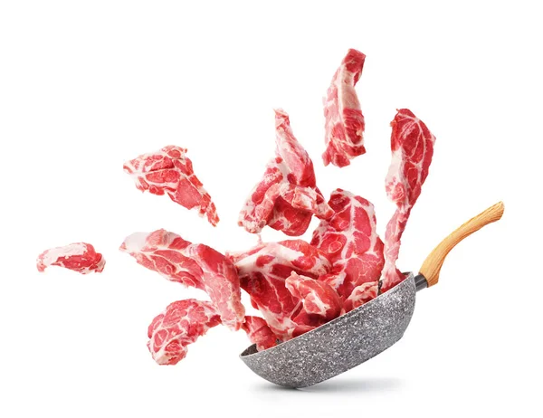 Cooking concept. Pieces of raw meat fly out of the pan isolated — Stock Photo, Image