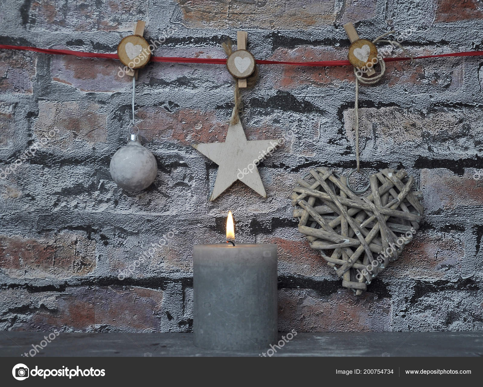Burning Candle And Christmas Decoration In Front Of Brick Wall Burning Candle And Christmas Decoration In Front Of Brick Wall
