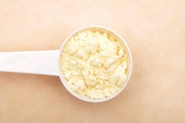 Kahverengi arka planda kaşık ölçmede Lupin unu