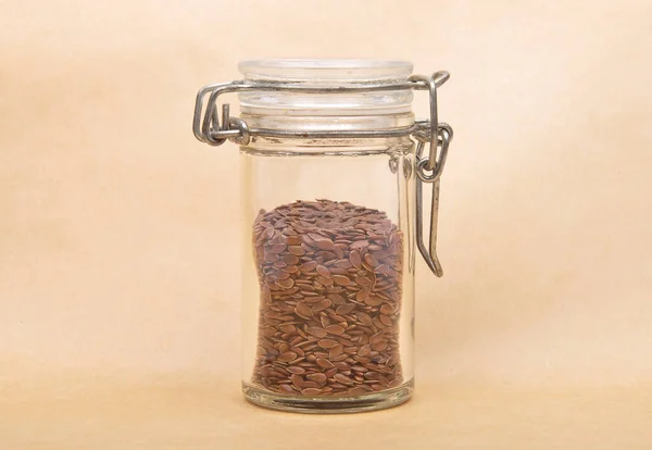 Linseed in glass on brown background — Stock Photo, Image