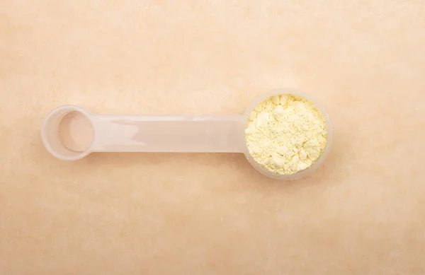 Lupin flour in measuring spoon on brown background — Stock Photo, Image