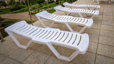 Turistik bir tatil beldesindeki yüzme havuzunda ücretsiz güneşlenme yatakları..