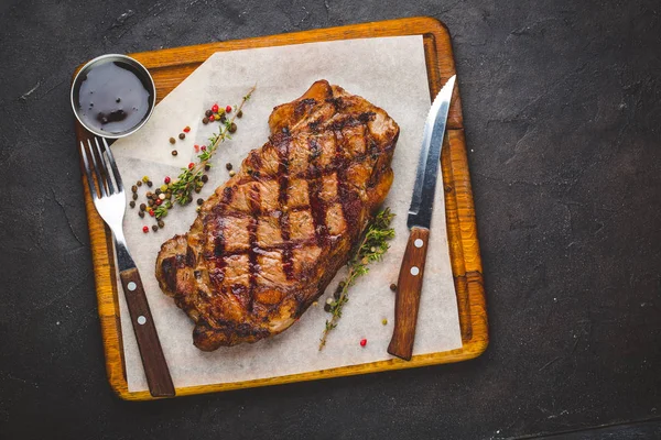 ジューシーなグリル大きなサーロイン ステーキ ハーブと塩を添えて まな板の上の横にあるナイフとフォーク — ストック写真