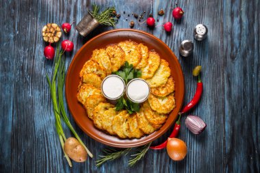 Ekşi krema ve dereotu ahşap arka plan üzerinde patates pancakes.