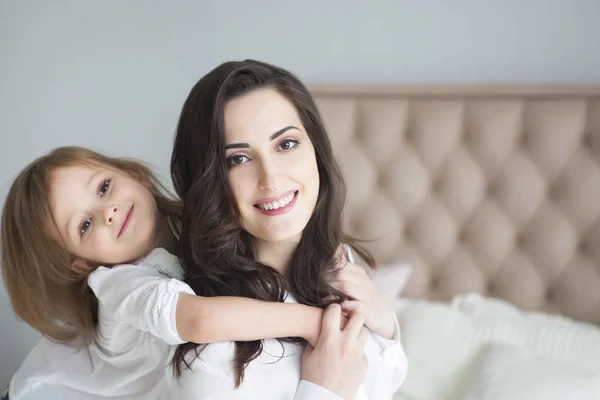 小さな娘と朝の抱擁で若い女性 愛と家族の概念 — ストック写真