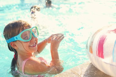 Açık havuzda eğleniyor bir küçük kız. Yaz tatil kavramı