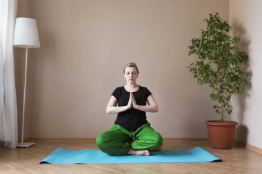 Orta yaşlı veya Olgun kadın kapalı yoga yaparken