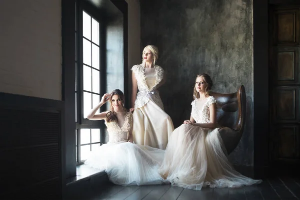 Τρεις Νεαρές Γυναίκες Κοντά Παράθυρο Που Φορούν Νυφικά Φορέματα — Φωτογραφία Αρχείου