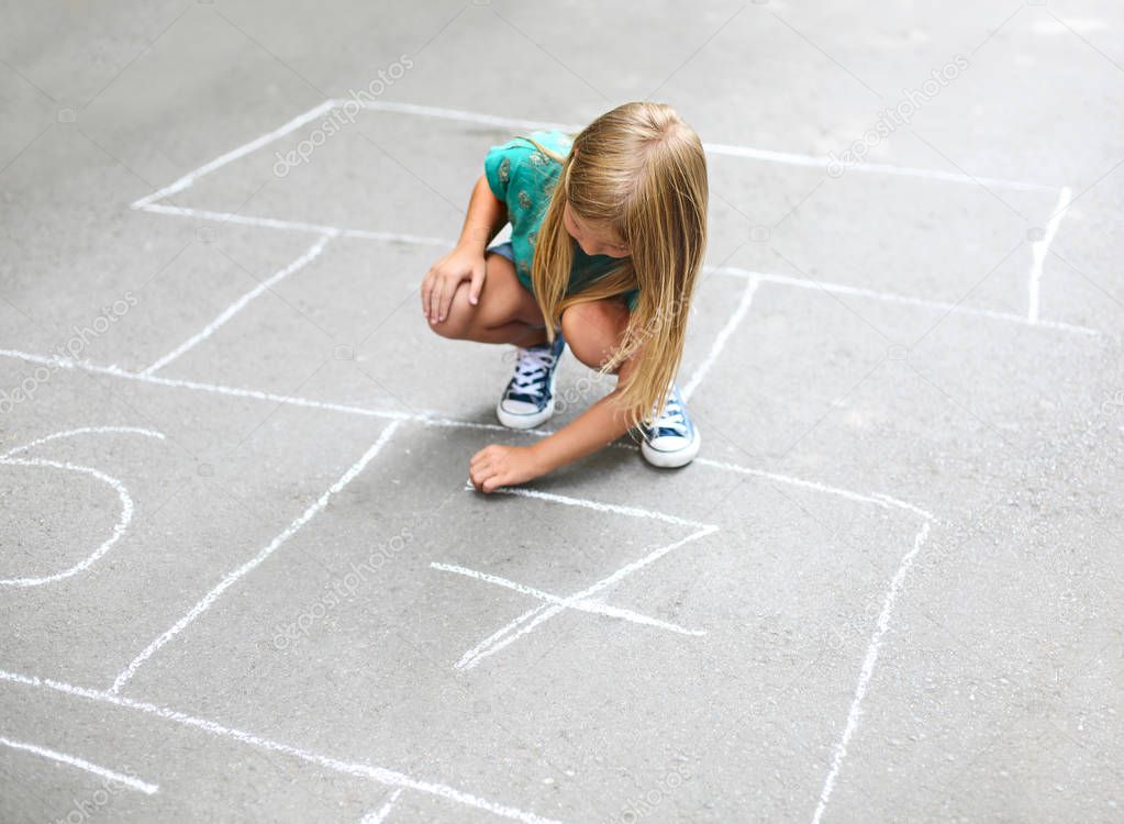 Kid playing hopscotch on playground outdoors, children outdoor activities