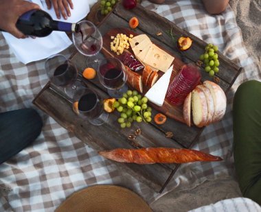 İnsanlar açık şarap kırmızı içme. Sahilde yaz pikniği. Üstten görünüm. Piknik