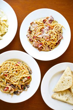 İtalyan makarna spagetti domates, proshutto, deniz ürünleri ve ekmek masanın üzerine çeşitli tür